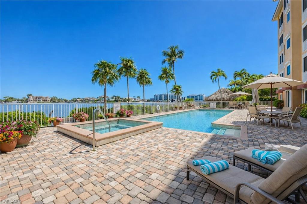 Community pool featuring a patio area, a hot tub, and outdoor dining area