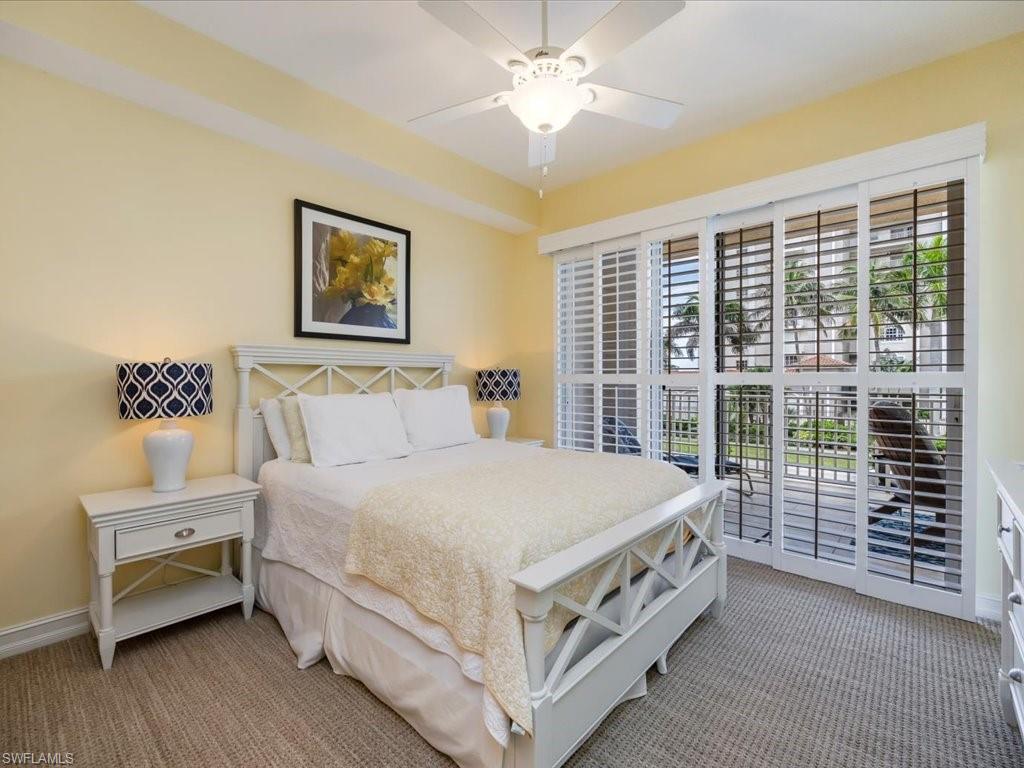 Carpeted bedroom featuring access to outside and ceiling fan