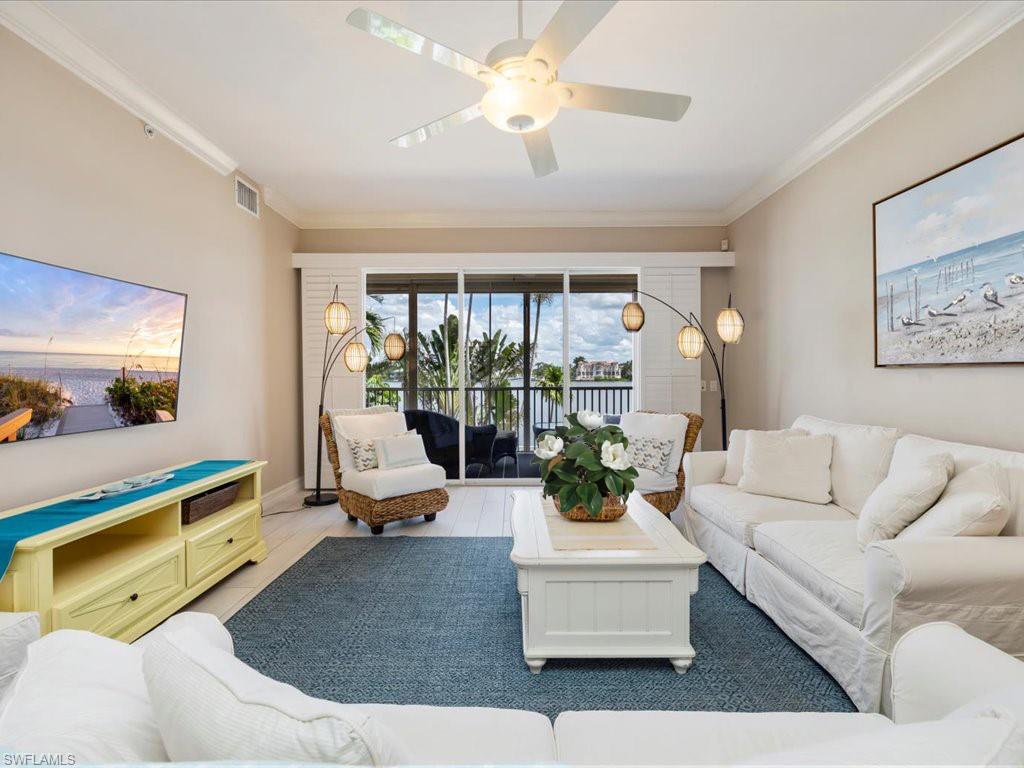 Living room with ornamental molding, wood finished floors, and ceiling fan