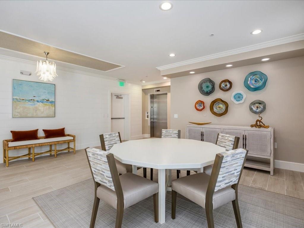 Dining room featuring recessed lighting, wood tiled floors, crown molding, elevator, and a chandelier