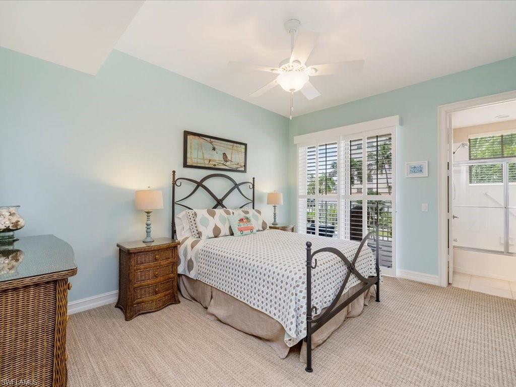 Carpeted bedroom with multiple windows and a ceiling fan