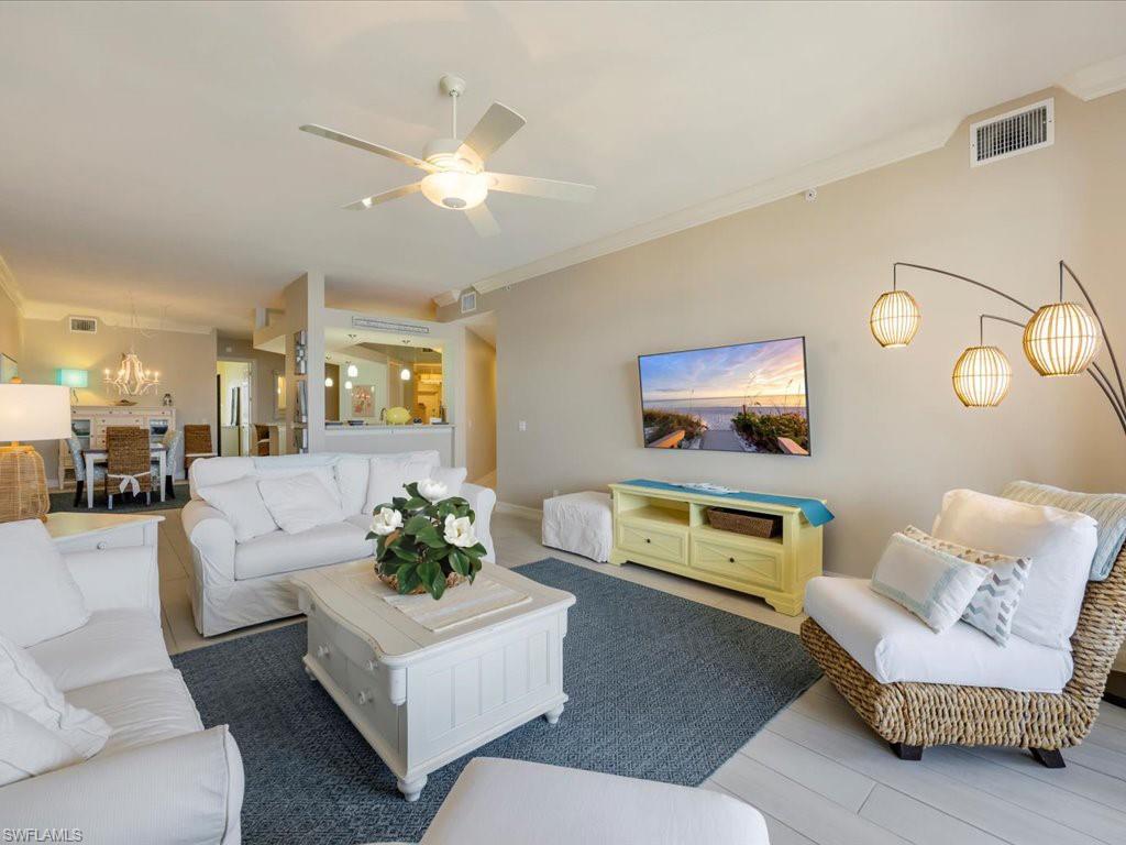 Living area with crown molding, a ceiling fan, and wood finished floors