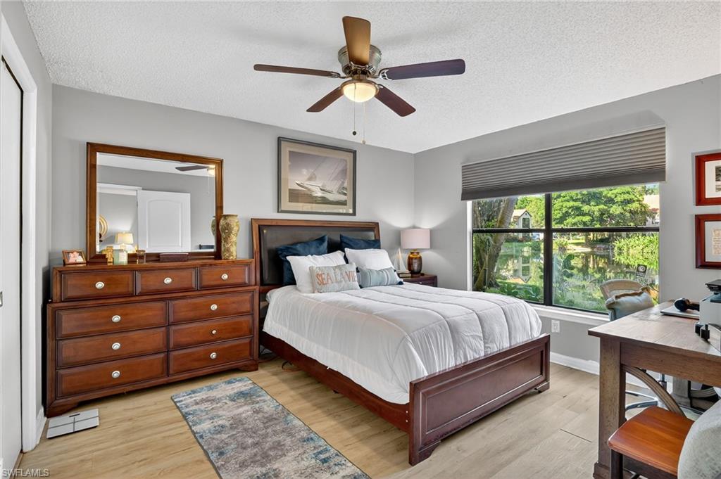 Bedroom with a textured ceiling, Luxury Vinyl Planking flooring, and Views of the pond !!