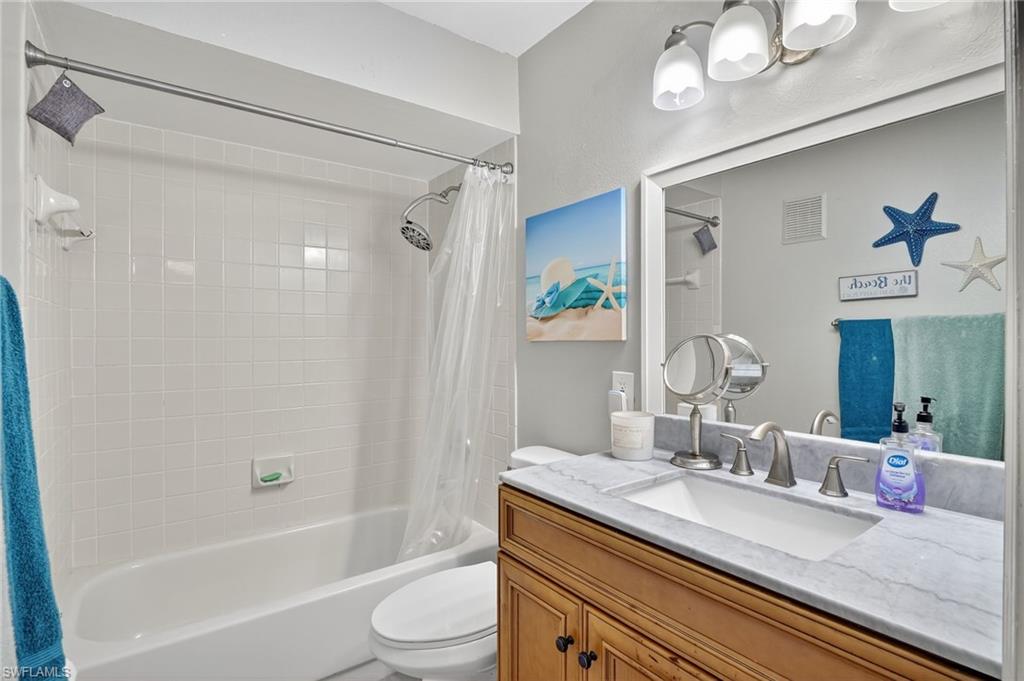 Guest Bathroom featuring shower / bath combination with curtain and vanity