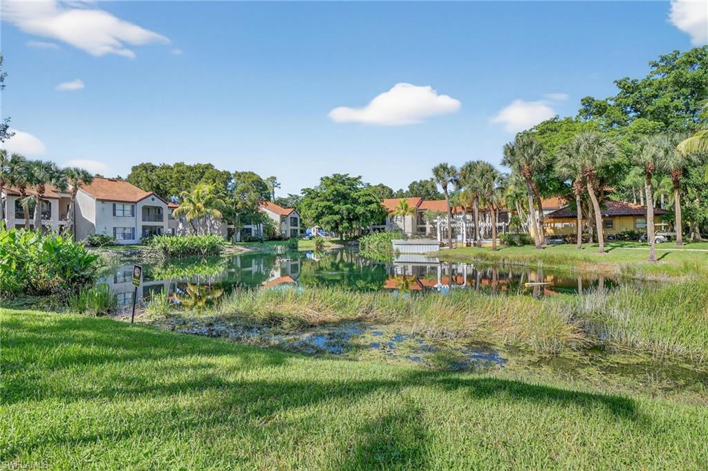 View of home's community with a water view and a lawn