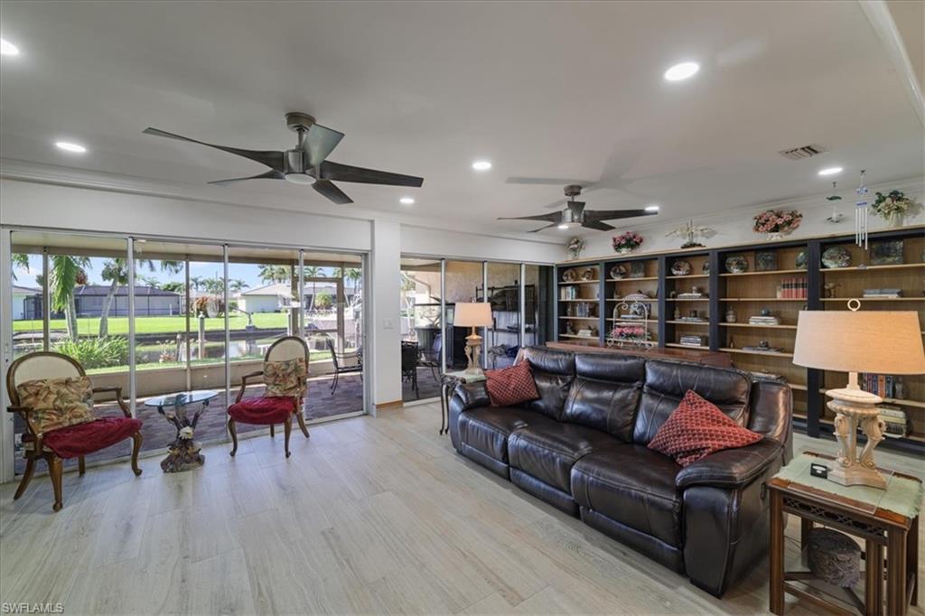 Living area with recessed lighting, light wood-style floors, crown molding, and ceiling fan