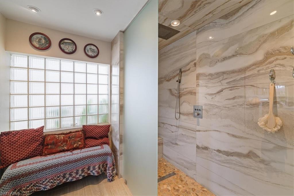 Full bath with a marble finish shower, recessed lighting, and light wood finished floors