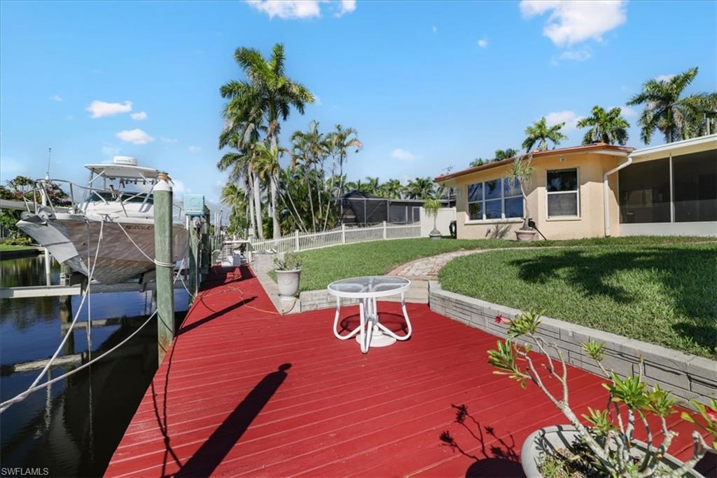 Dock area featuring a water view, boat lift, and a sunroom