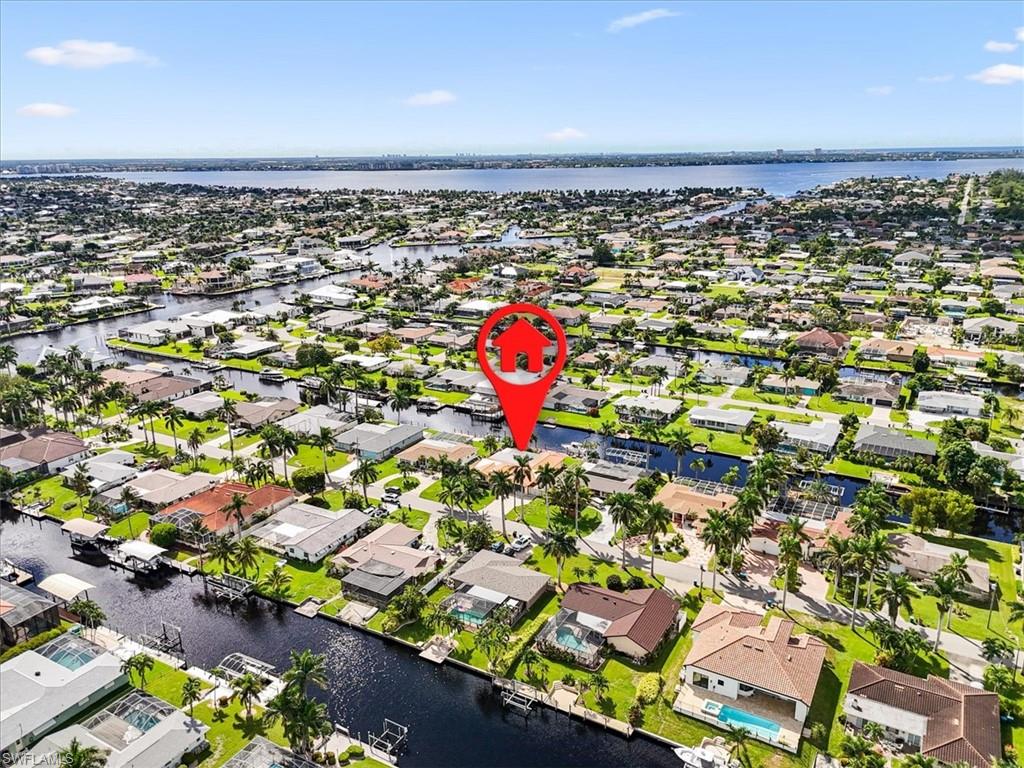 Aerial view of property and surrounding area featuring a large body of water and nearby suburban area