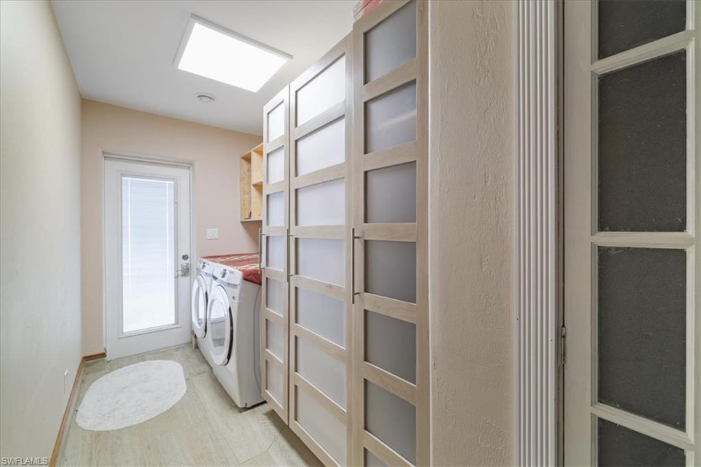 Washroom featuring washer and clothes dryer and cabinet space and custom pantry.