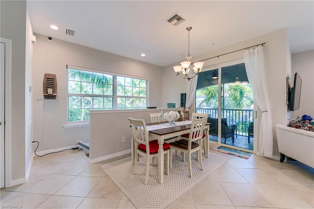Dining space with light tile patterned floors, a chandelier, and recessed lighting