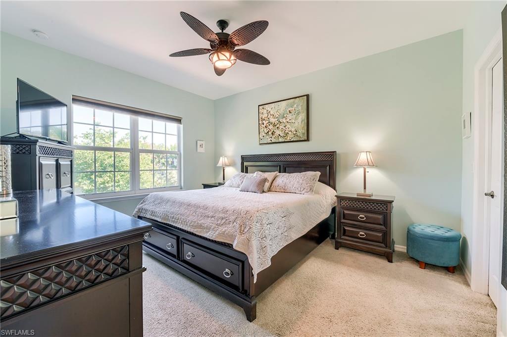 Bedroom with light colored carpet and a ceiling fan