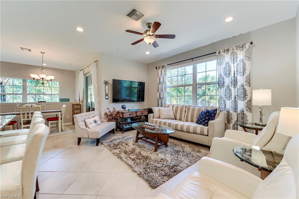 Living room with light tile patterned floors, a chandelier, recessed lighting, and a ceiling fan