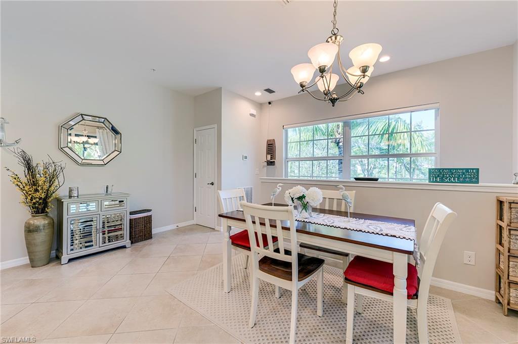 Dining space with light tile patterned flooring and a chandelier