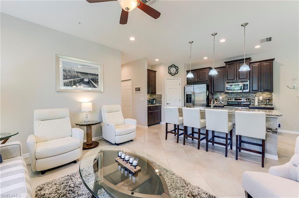 Living area with light tile patterned floors, ceiling fan, and recessed lighting