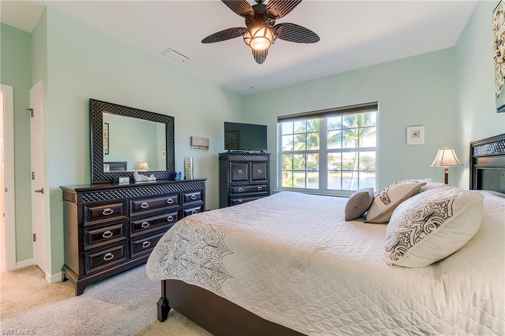 Bedroom with light colored carpet and a ceiling fan