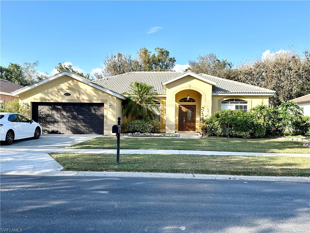 View of front facade featuring a garage and a front yard