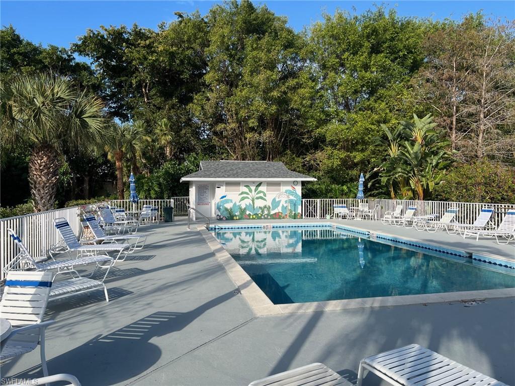 Community pool featuring a patio area and view of scattered trees