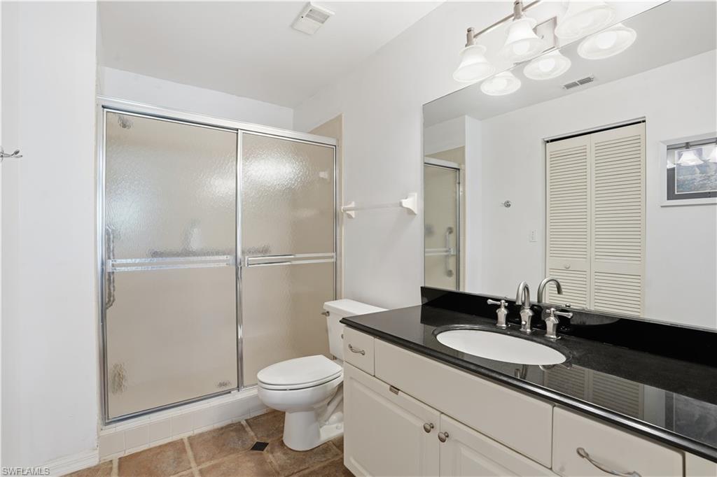 Bathroom with vanity, a stall shower, a closet, and light tile patterned flooring