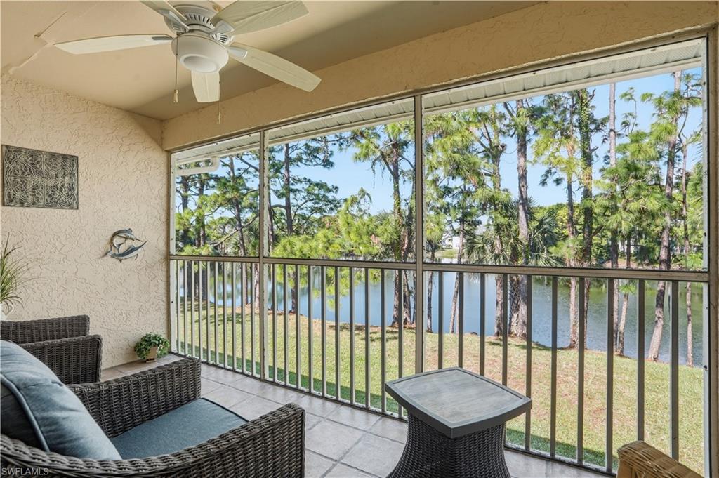 Sunroom with a water view, a ceiling fan, and a balcony