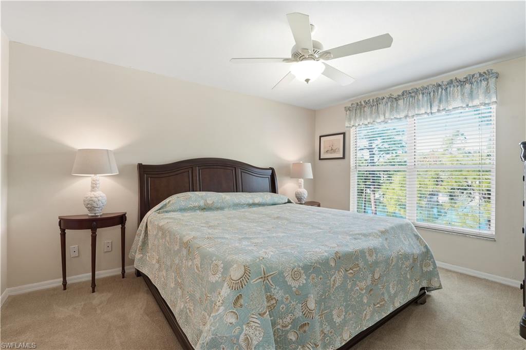Bedroom with light colored carpet and a ceiling fan