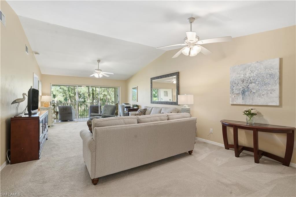 Living room with carpet, lofted ceiling, and ceiling fan