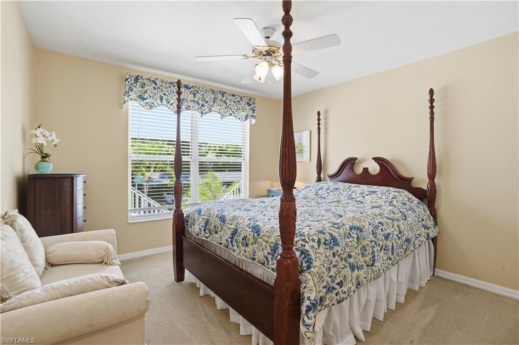 Bedroom with ceiling fan and light carpet