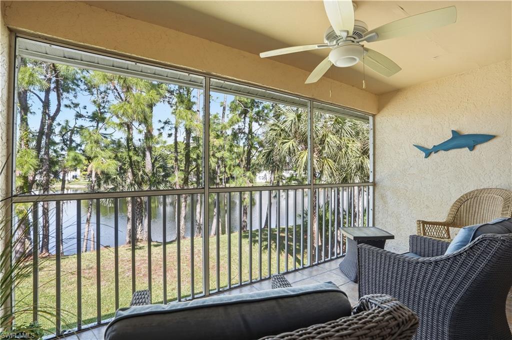 Sunroom with a water view, a balcony, and a ceiling fan