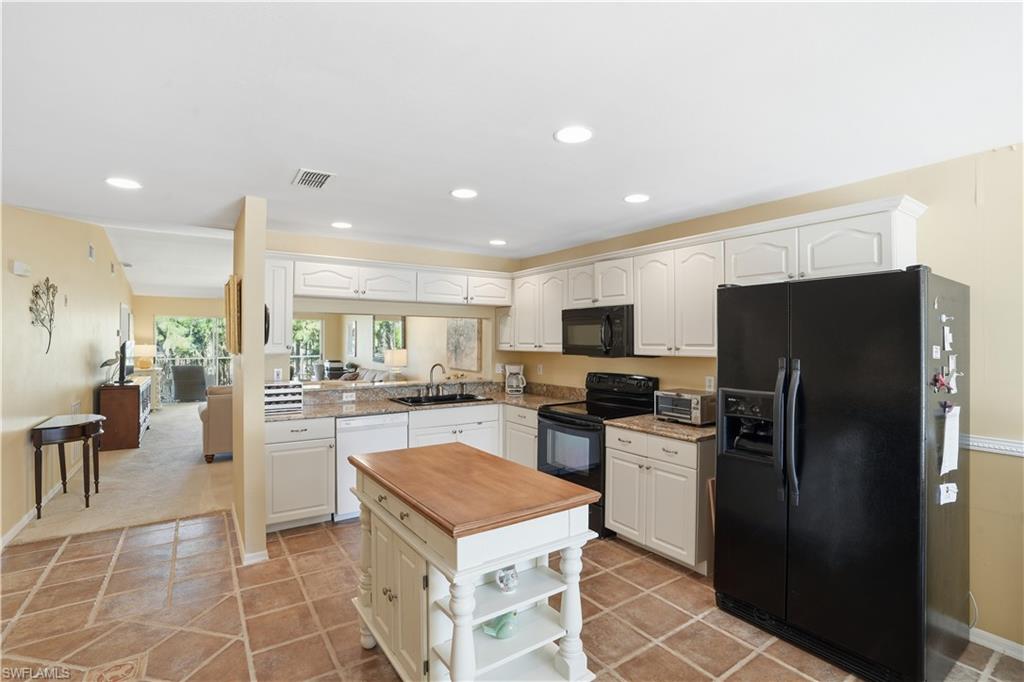 Kitchen featuring black appliances, white cabinets, recessed lighting, light stone countertops, and light tile patterned floors