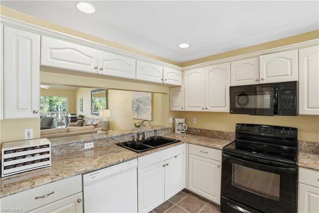 Kitchen with black appliances, white cabinets, recessed lighting, light stone counters, and light tile patterned flooring