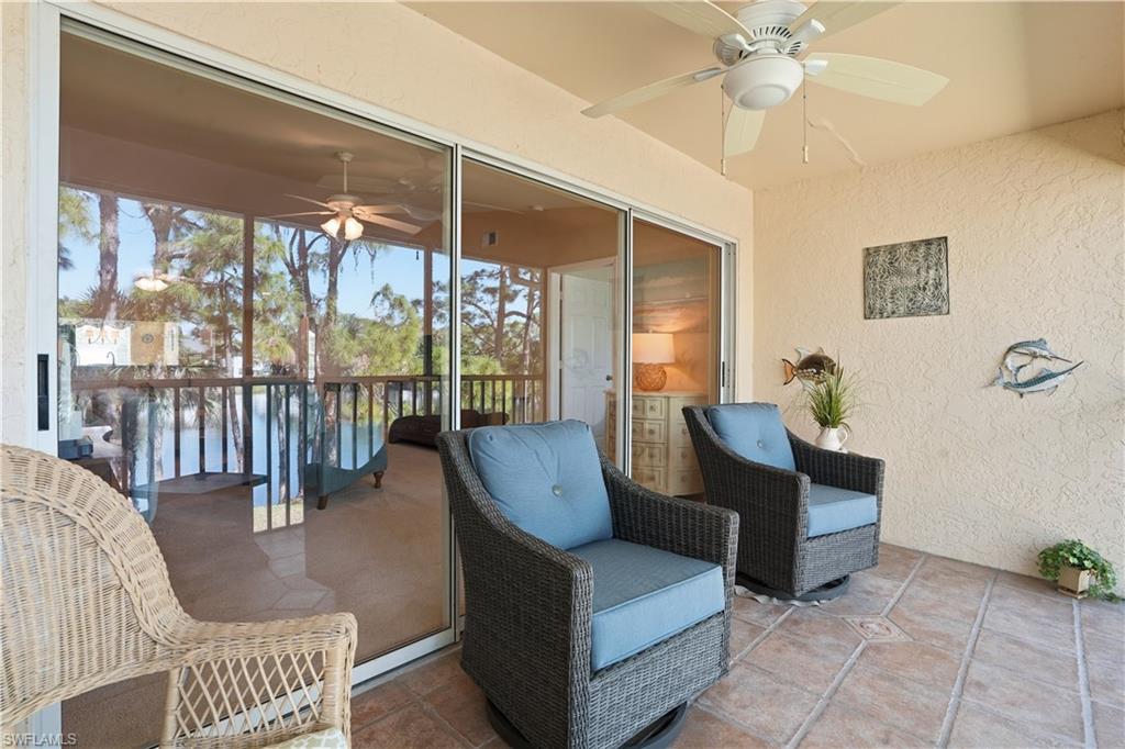 Sunroom / solarium featuring a ceiling fan and a water view