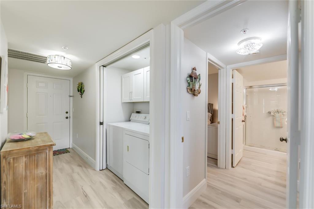 Laundry area featuring light wood-style flooring, cabinet space, and separate washer and dryer