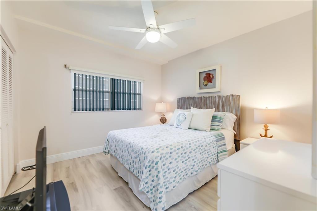 Bedroom with light wood-style flooring, ceiling fan, and a closet