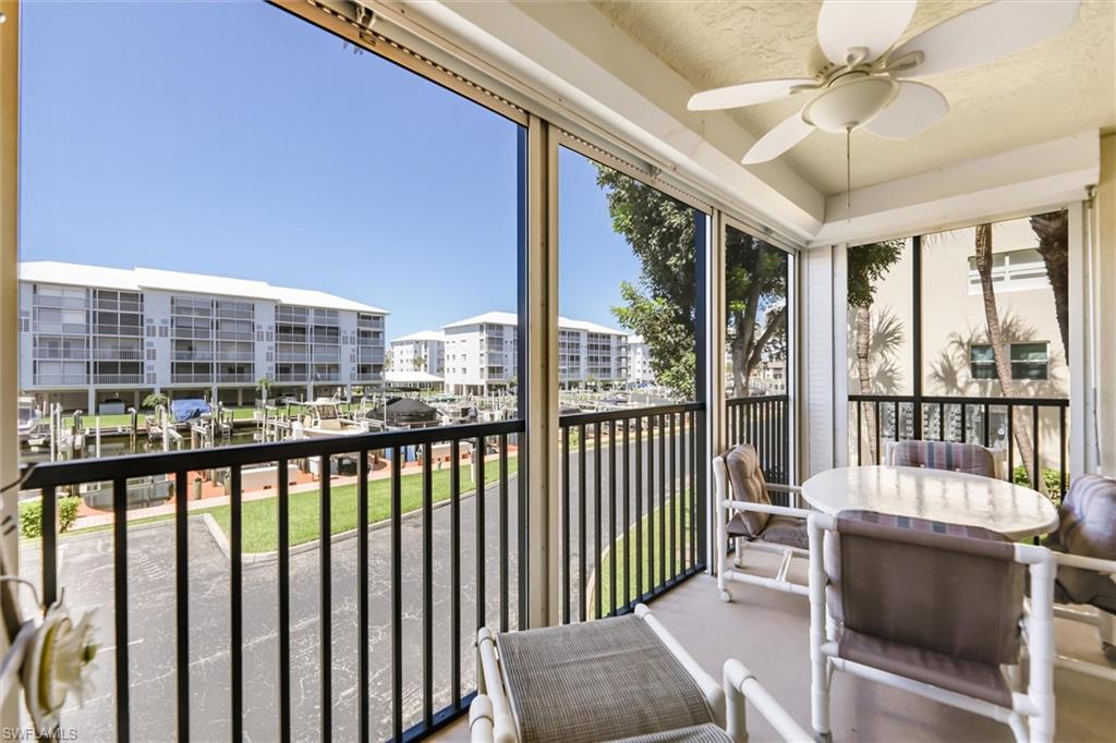 Sunroom / solarium featuring a ceiling fan, a balcony, and a water view
