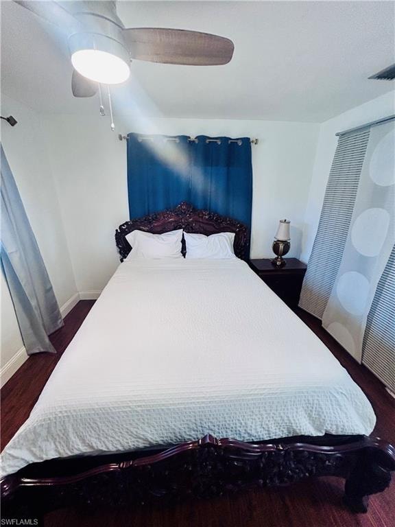 Bedroom with a ceiling fan and dark wood-style floors