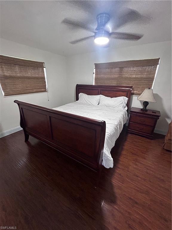 Bedroom featuring dark wood-type flooring, a ceiling fan, and a textured ceiling