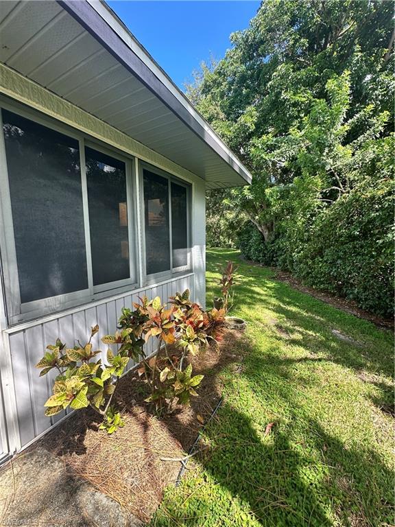 View of property exterior with a yard and a sunroom
