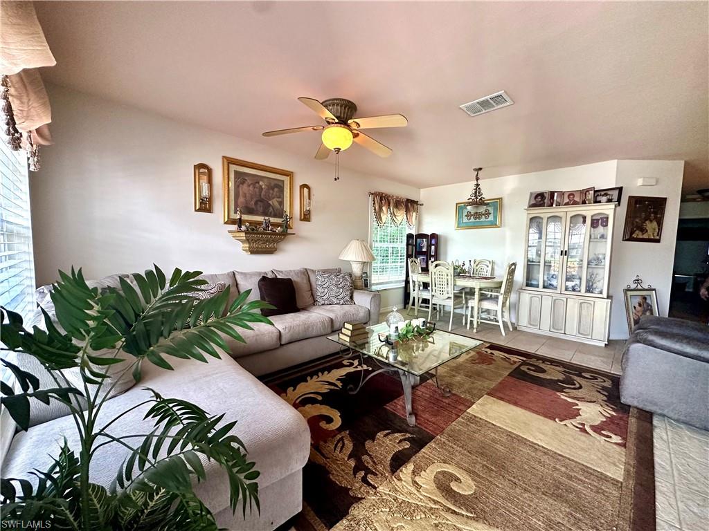 Living room with tile patterned flooring and a ceiling fan