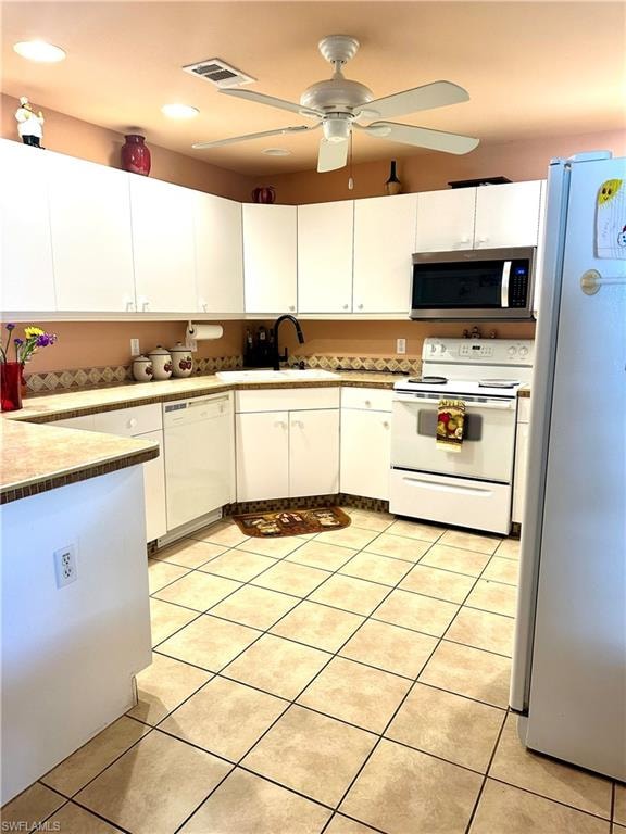 Kitchen with white appliances, white cabinetry, light tile patterned flooring, and recessed lighting