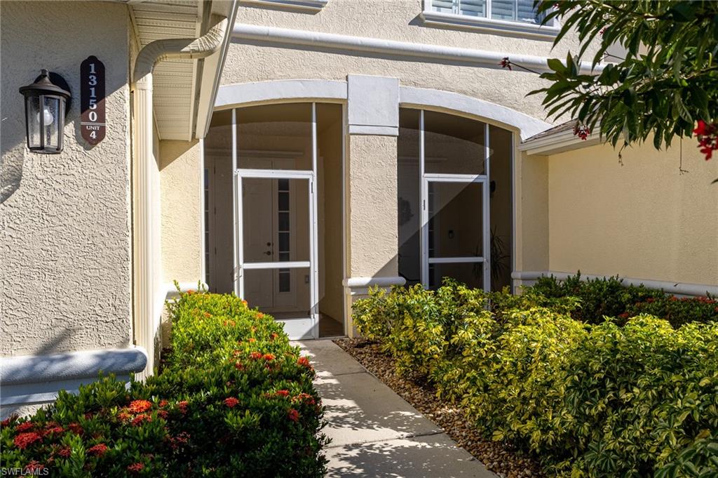 Doorway to property featuring stucco siding and a sunroom