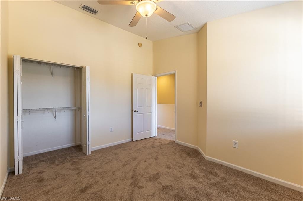 Unfurnished bedroom with carpet, a ceiling fan, and a closet