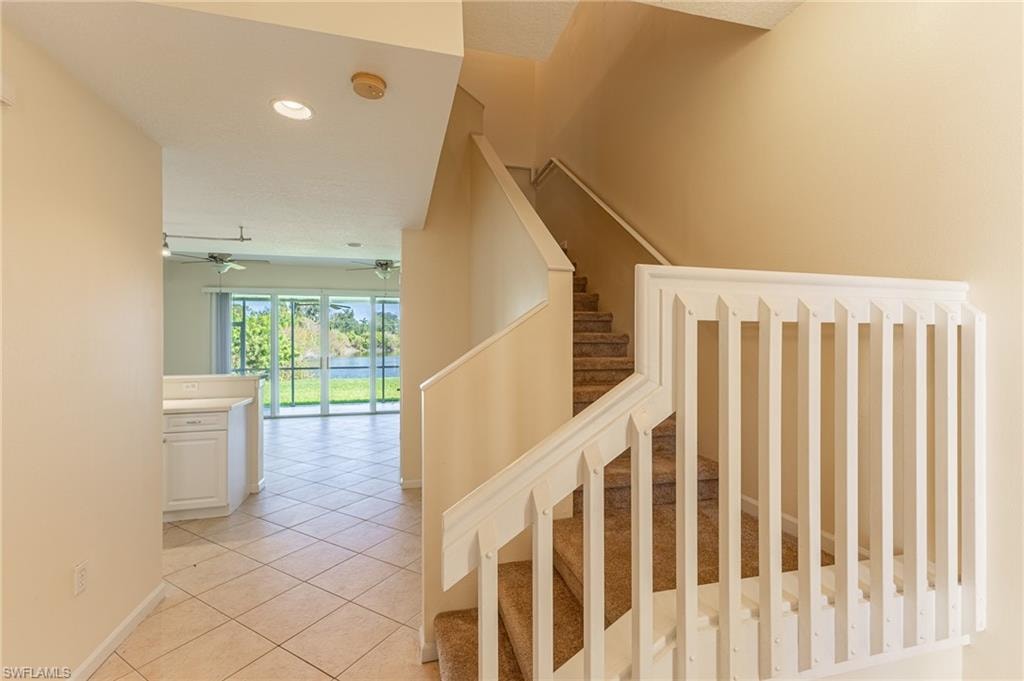 Stairs with tile patterned flooring and recessed lighting