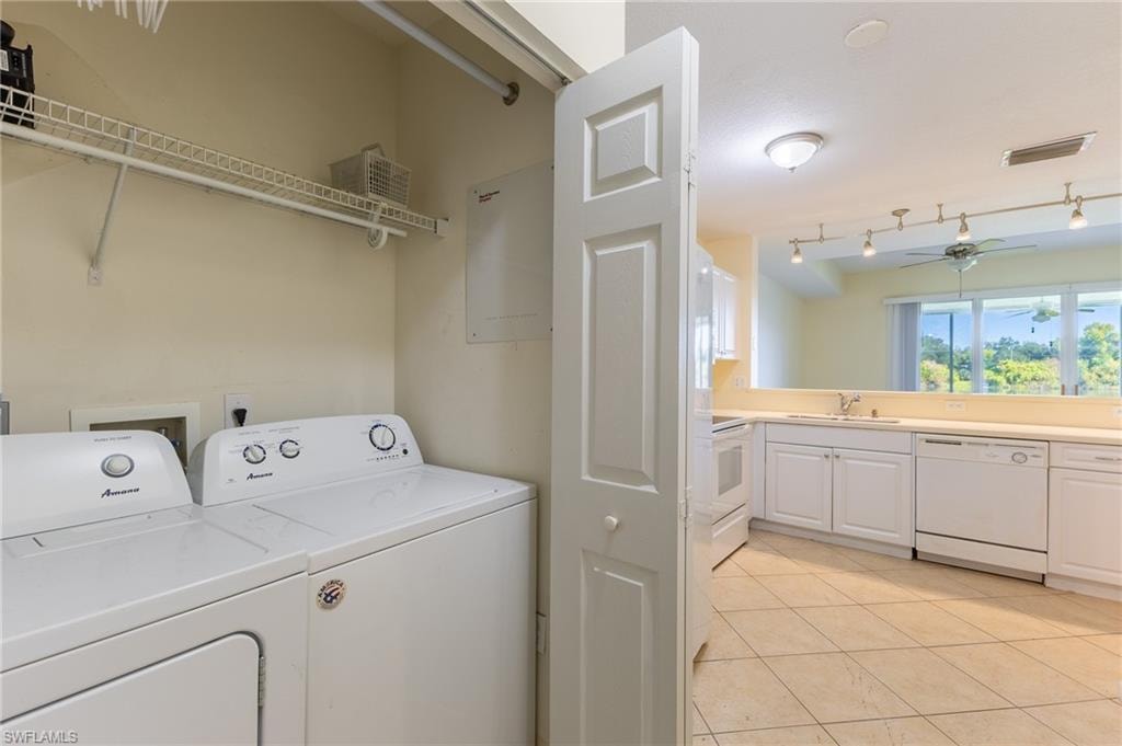 Laundry area with light tile patterned floors, separate washer and dryer, and a ceiling fan