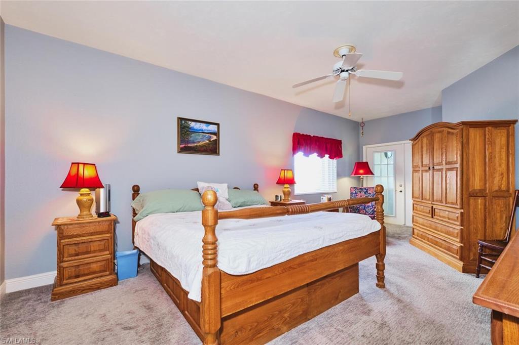 Primary Bedroom with newer light carpet and a ceiling fan