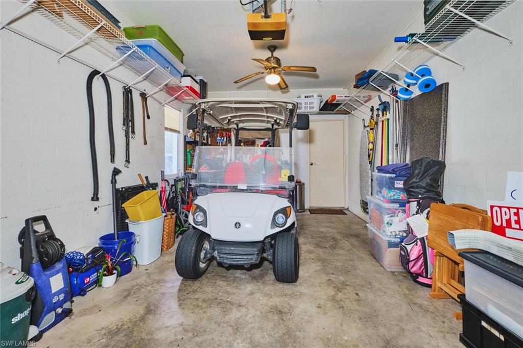 Garage featuring workbench and entry to living area. Complete with garage door opener  and a ceiling fan