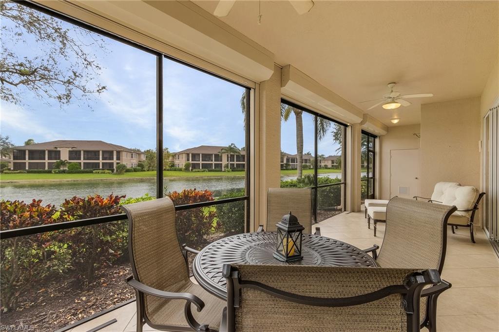 Sunroom / solarium featuring ceiling fan, tile patterned flooring, and a water view