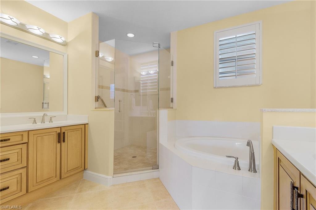 Bathroom featuring vanity, a shower stall, a bath, light tile patterned floors, and recessed lighting
