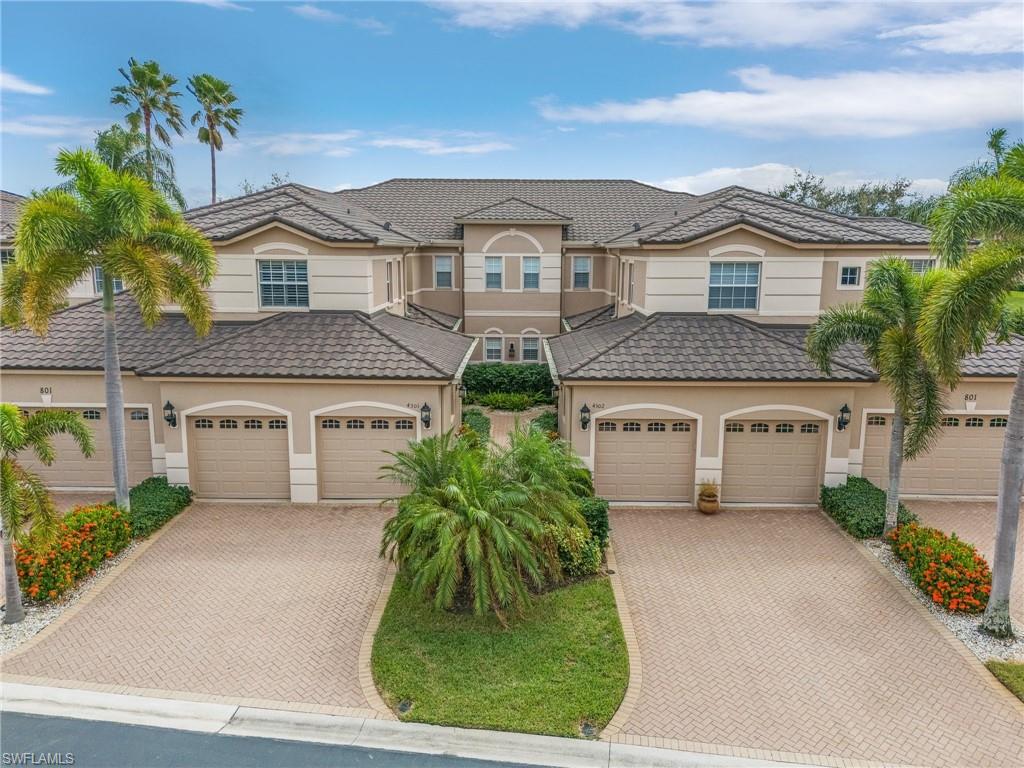 View of front of property with stucco siding, decorative driveway, and a garage