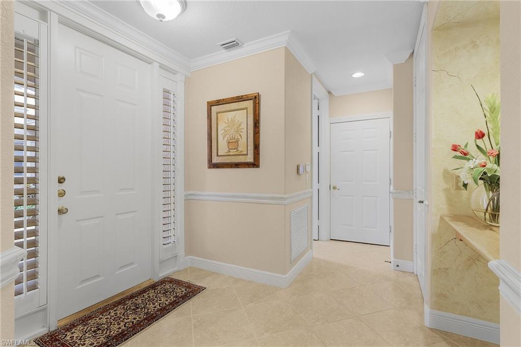 Entrance foyer featuring light tile patterned floors, ornamental molding, and recessed lighting