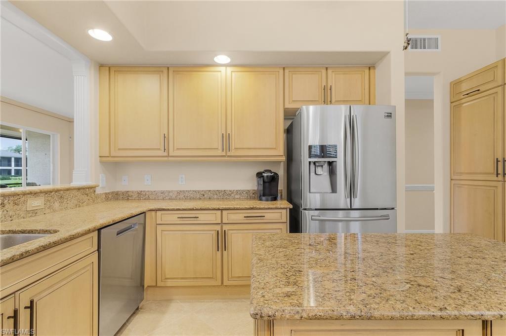 Kitchen with stainless steel appliances, recessed lighting, light brown cabinetry, light stone countertops, and light tile patterned flooring